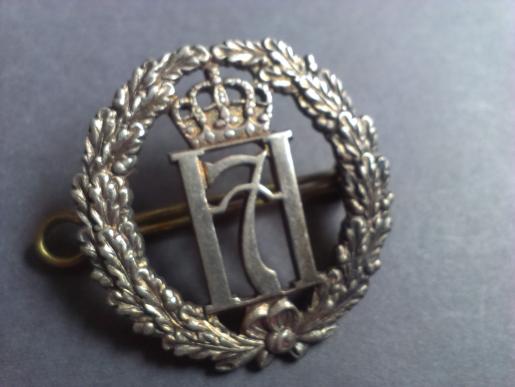 A neat example of a scarce Norwegian Free Forces British made Haakon 7 silver hallmarked capbadge