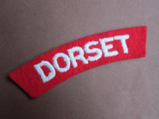 A nice single white on red embroided Dorset Regiment shoulder title 