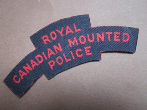 A nice and difficult to find British made Canadian Royal Canadian Mounted Police printed shoulder title 