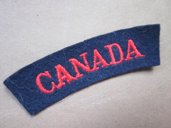 A good British made embroided glue i.e paste backing red on black Canada shoulder title ... Combined Operation/Navy ??
