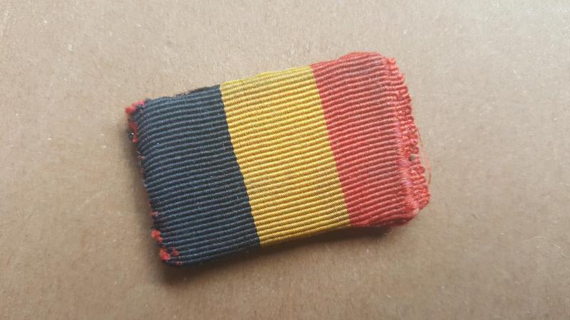 A nice little Belgium national flag made out of a piece of medal ribbon,as intended to wear by Belgium volunteers on there upper arm of there battle-dress blouse