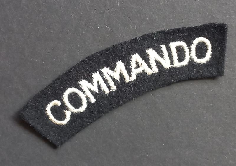 A superb - albeit regrettably single - mid war period white on black embroided commando shoulder title