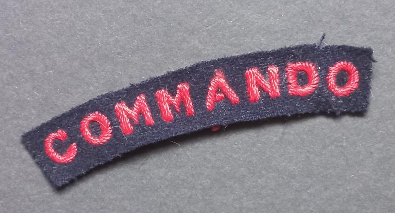 A superb - albeit regrettably single - early red on black embroided Commando shoulder title