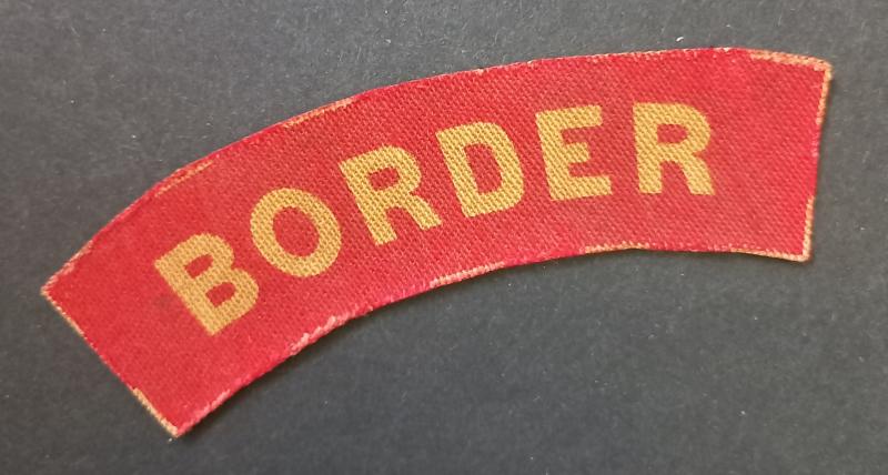 A attractive - albeit regrettably single - printed unissued Border Regiment shoulder title