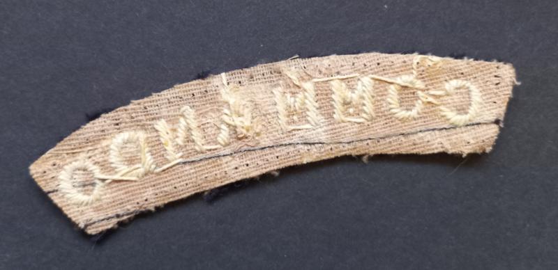A superb - albeit regrettably single - early white on black embroided commando shoulder title