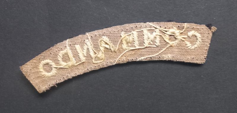 A superb - albeit regrettably single - early white on black embroided commando shoulder title